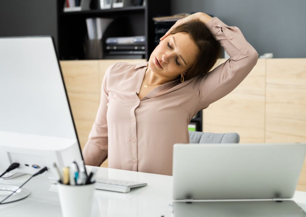 a lady stretching her neck while working from home