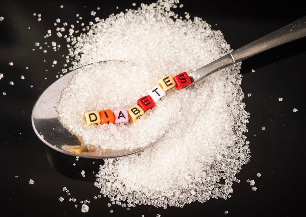 diabetes-written-on-beads-on-a-spoon-with-sugar-underneath-it