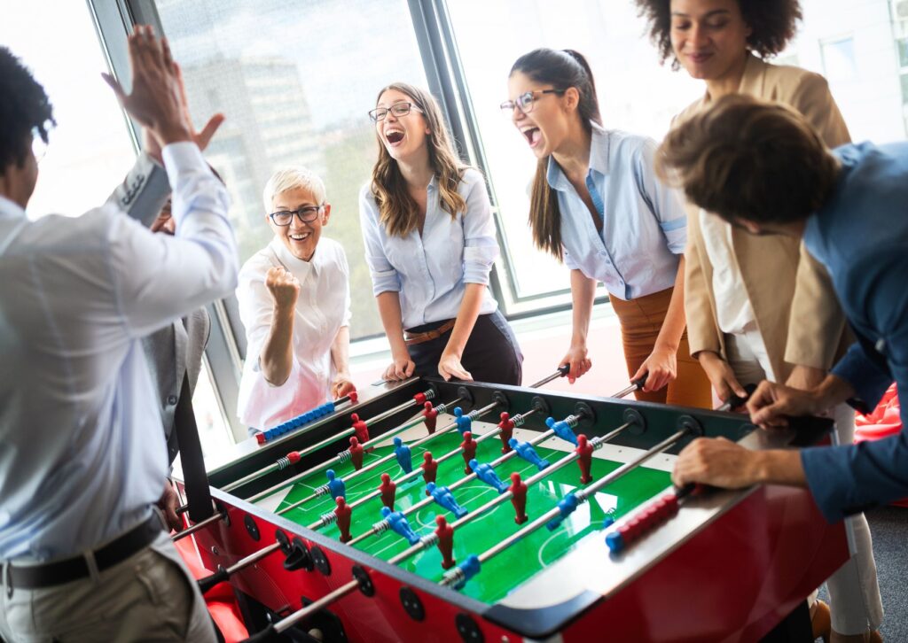 employees having fun playing table football