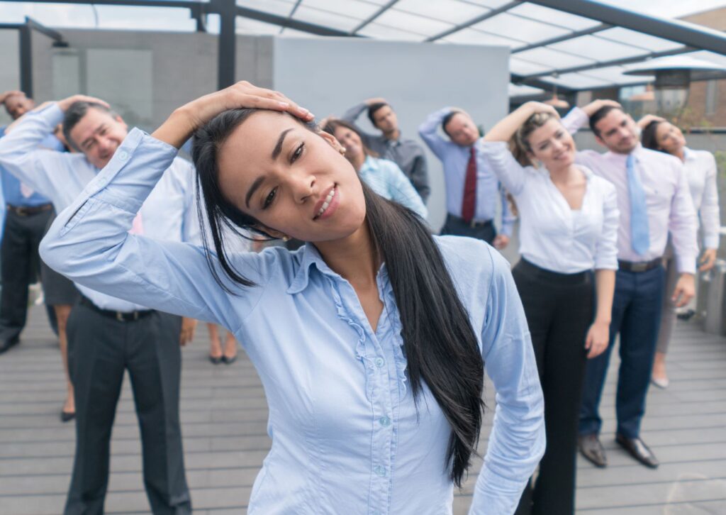 Employees stretching as part of their wellbeing activities in their team meeting