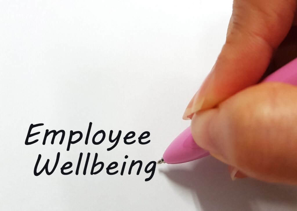 female hand writing employee wellbeing