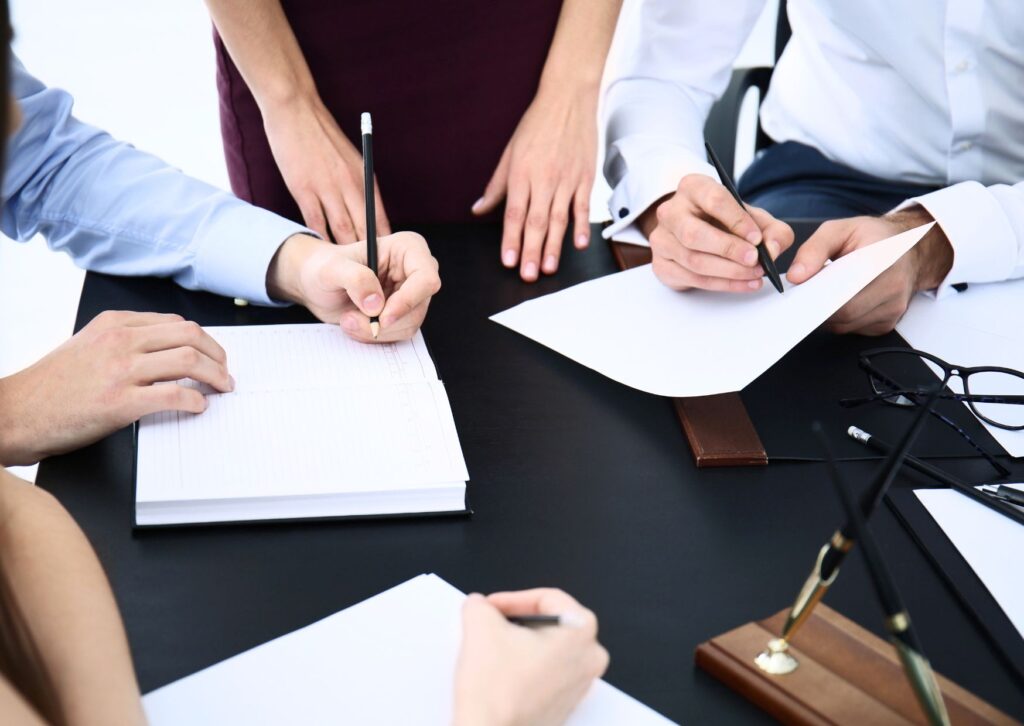 hands-writing-in-a-notepad-during-a-meeting