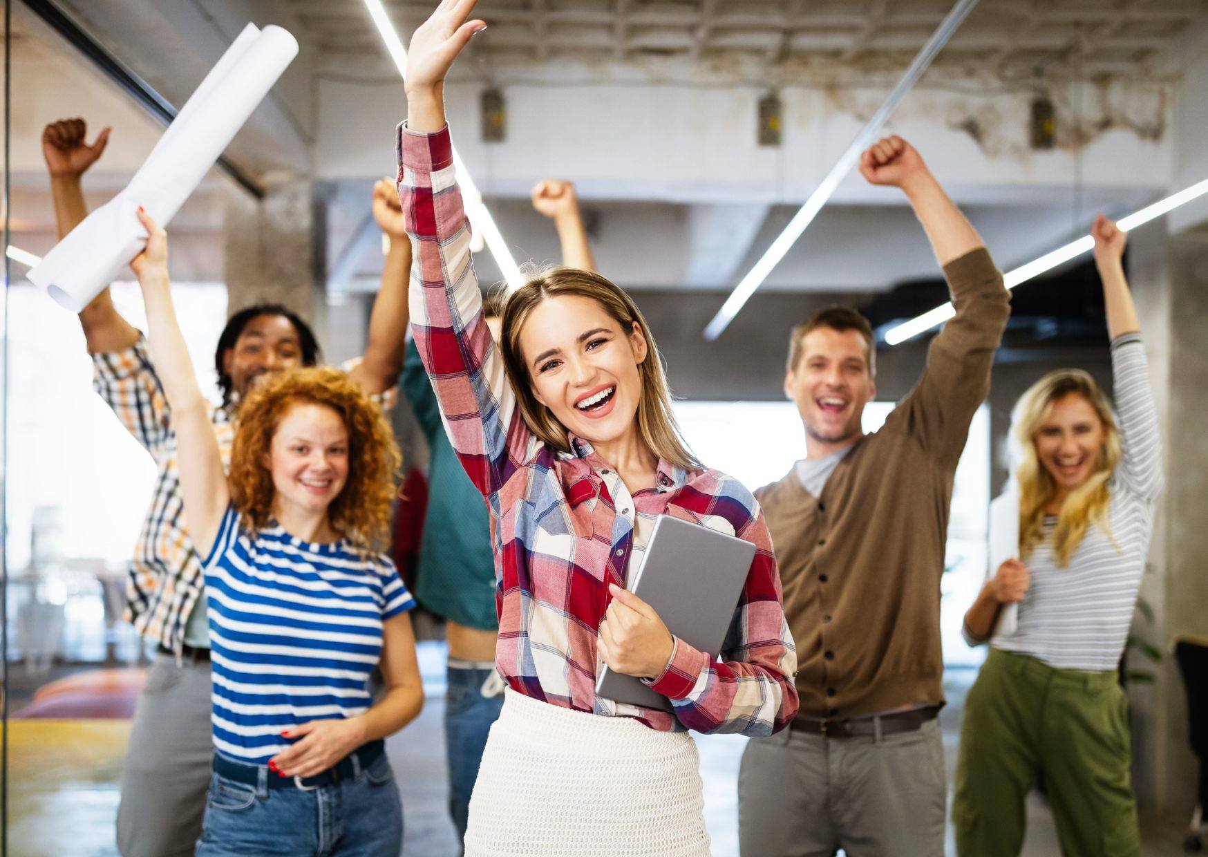 Happy-and-satisfied-employees-raising-their-hands-in-the-air