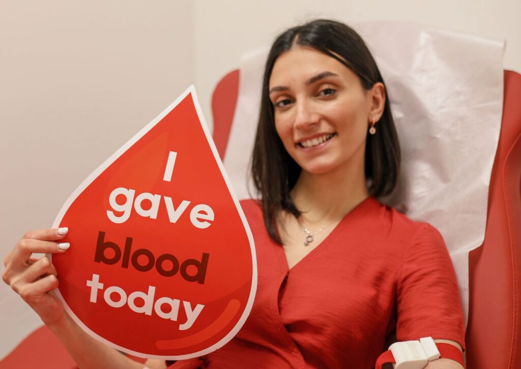 Lady-holding-a-sign-that-says-i-gave-blood-today-after-donating-blood