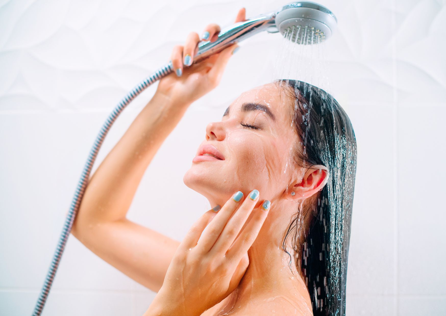 lady in cold shower putting water on her face