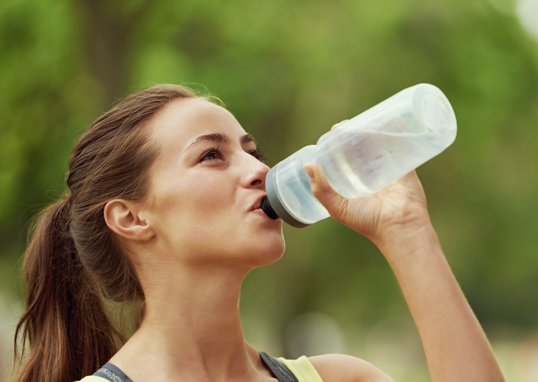 lady staying hydrated drinking water from a bottle