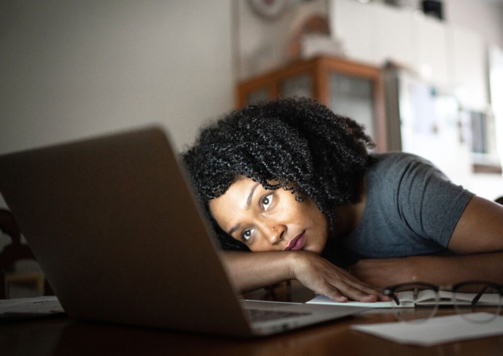 lady-tired-looking-at-her-laptop-laying-on-her-desk