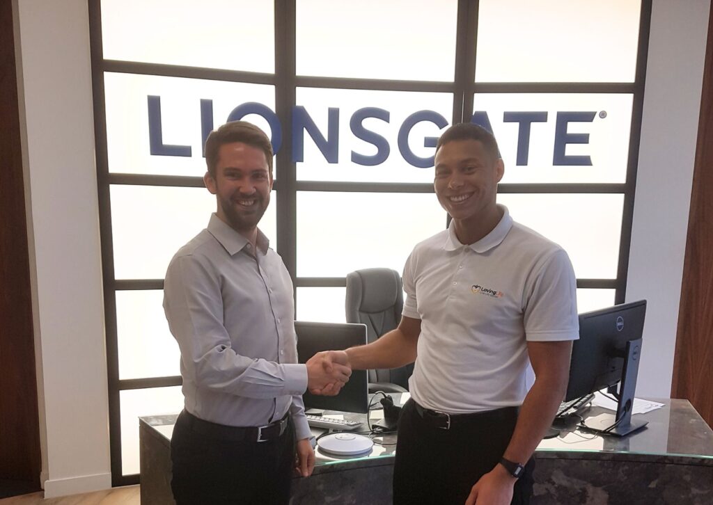 loving-life-founder-shaking-hands-with-lionsgate-office-manager-infront-of-the-lionsgate-sign