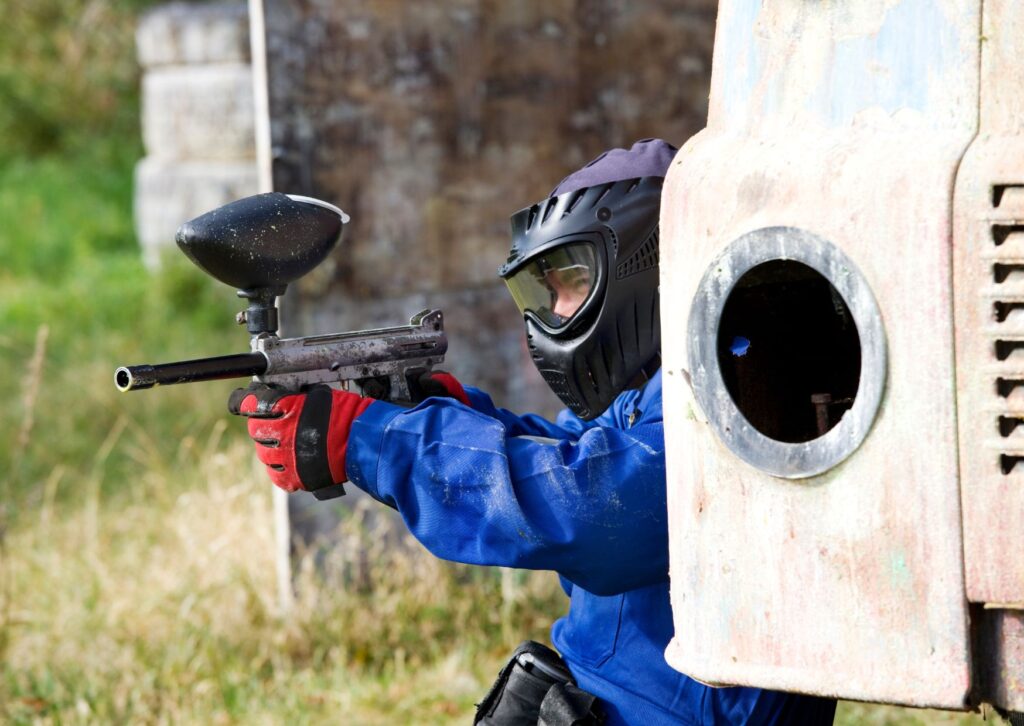 Man-paint-balling-hiding-behind-vehicle