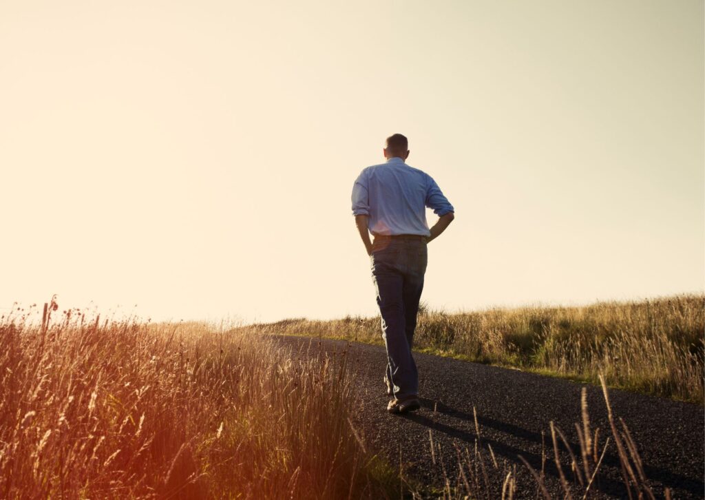 man-walking-in-a-field-alone-along-a-toe-path