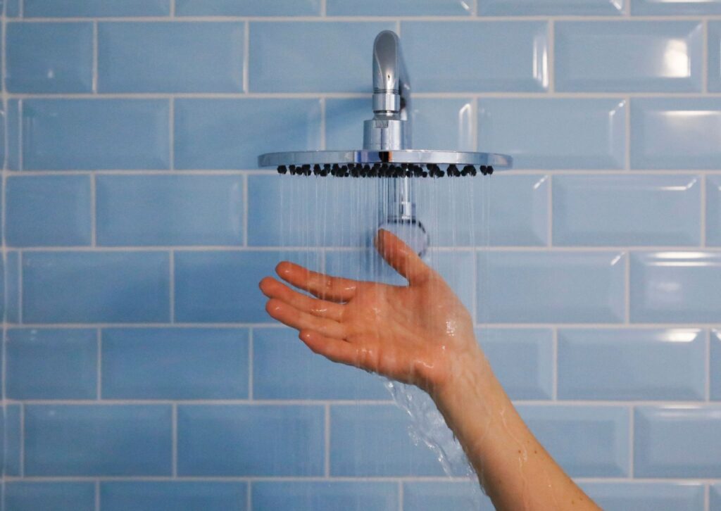 shower head with hand underneath it