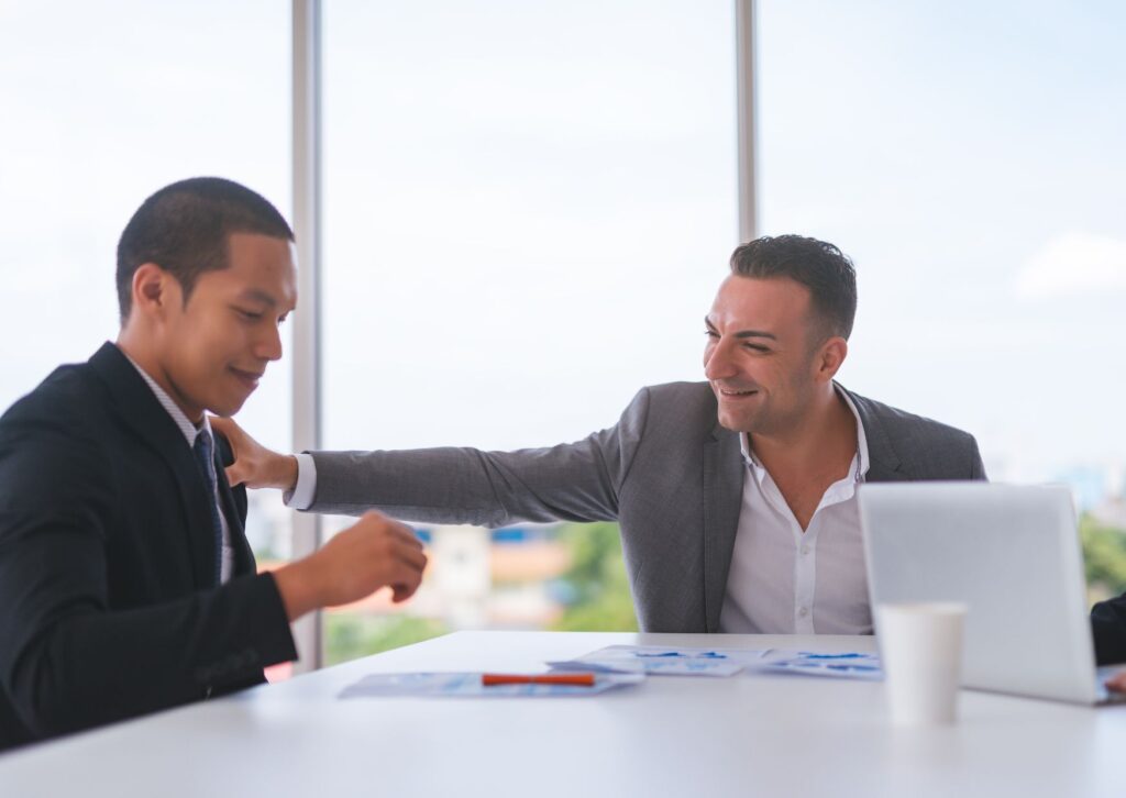 two male employees in an office being kind to each other